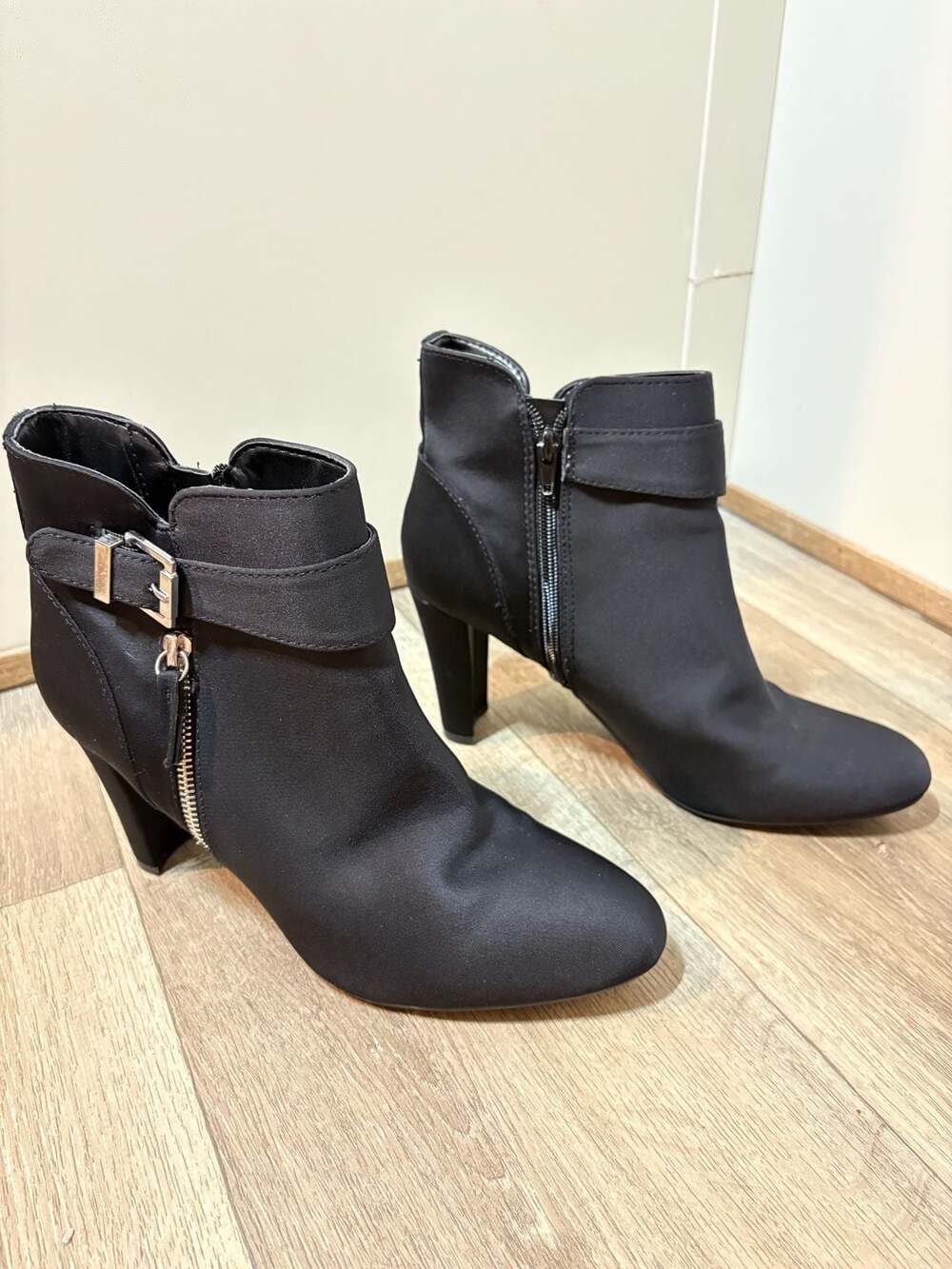 Black textile ankle boot  with a decorative buckle strap around the ankle.